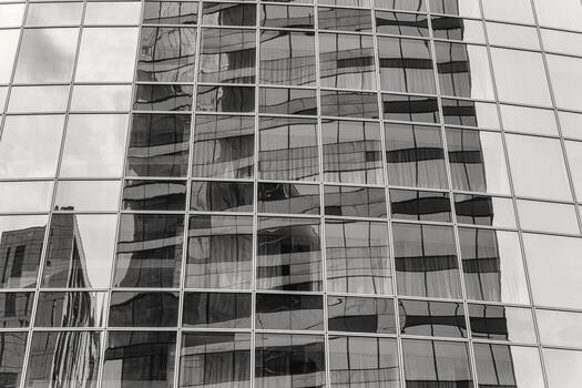 Fragment of a modern office building. Abstract geometric background. Part of a skyscraper with glass windows. Black and white. photo