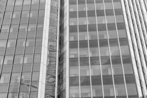 Fragment of a modern office building. Abstract geometric background. Part of a skyscraper with glass windows. Black and white. photo
