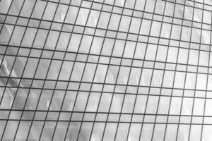 Fragment of a modern office building. Abstract geometric background. Part of a skyscraper with glass windows. Black and white. photo