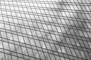 Fragment of a modern office building. Abstract geometric background. Part of a skyscraper with glass windows. Black and white. photo
