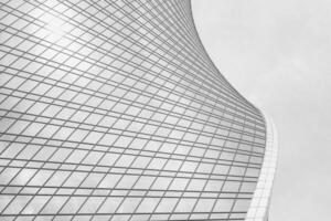 Fragment of a modern office building. Abstract geometric background. Part of a skyscraper with glass windows. Black and white. photo