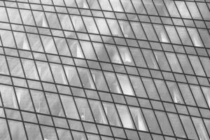 Fragment of a modern office building. Abstract geometric background. Part of a skyscraper with glass windows. Black and white. photo