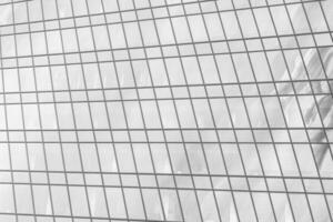 Fragment of a modern office building. Abstract geometric background. Part of a skyscraper with glass windows. Black and white. photo