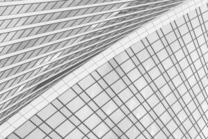 Fragment of a modern office building. Abstract geometric background. Part of a skyscraper with glass windows. Black and white. photo