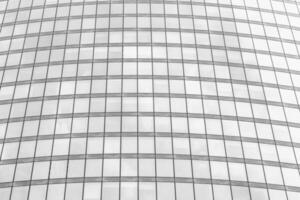 Fragment of a modern office building. Abstract geometric background. Part of a skyscraper with glass windows. Black and white. photo