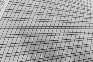 Fragment of a modern office building. Abstract geometric background. Part of a skyscraper with glass windows. Black and white. photo
