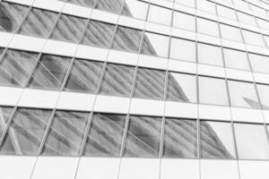 Fragment of a modern office building. Abstract geometric background. Part of a skyscraper with glass windows. Black and white. photo