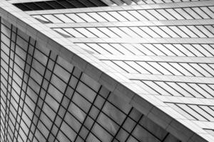Fragment of a modern office building. Abstract geometric background. Part of a skyscraper with glass windows. Black and white. photo