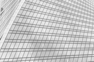 Fragment of a modern office building. Abstract geometric background. Part of a skyscraper with glass windows. Black and white. photo