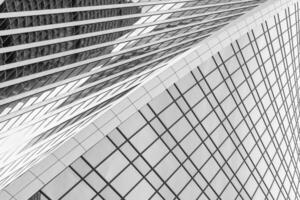 Fragment of a modern office building. Abstract geometric background. Part of a skyscraper with glass windows. Black and white. photo