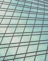 Fragment of a modern office building. Abstract geometric background. Part of a skyscraper with glass windows. photo
