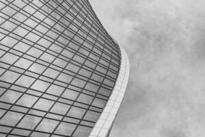 Fragment of a modern office building. Abstract geometric background. Part of a skyscraper with glass windows. Black and white. photo