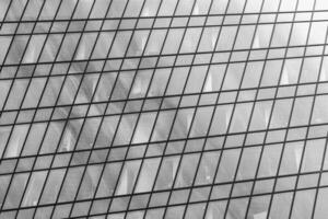 Fragment of a modern office building. Abstract geometric background. Part of a skyscraper with glass windows. Black and white. photo