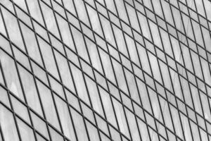 Fragment of a modern office building. Abstract geometric background. Part of a skyscraper with glass windows. Black and white. photo
