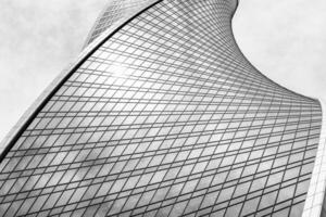 Fragment of a modern office building. Abstract geometric background. Part of a skyscraper with glass windows. Black and white. photo