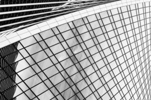 Fragment of a modern office building. Abstract geometric background. Part of a skyscraper with glass windows. Black and white. photo
