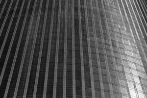 Fragment of a modern office building. Abstract geometric background. Part of a skyscraper with glass windows. Black and white. photo