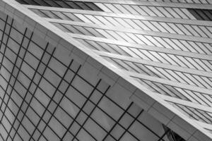 Fragment of a modern office building. Abstract geometric background. Part of a skyscraper with glass windows. Black and white. photo