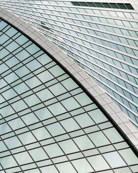 Fragment of a modern office building. Abstract geometric background. Part of a skyscraper with glass windows. photo