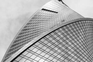 Fragment of a modern office building. Abstract geometric background. Part of a skyscraper with glass windows. Black and white. photo