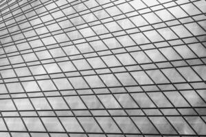 Fragment of a modern office building. Abstract geometric background. Part of a skyscraper with glass windows. Black and white. photo