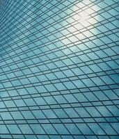 Fragment of a modern office building. Abstract geometric background. Part of a skyscraper with glass windows. photo