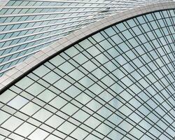 Fragment of a modern office building. Abstract geometric background. Part of a skyscraper with glass windows. photo