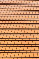 Fragment of a modern office building. Abstract geometric background. Part of a skyscraper with glass windows. photo