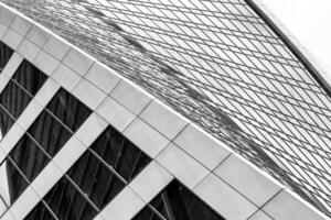 Fragment of a modern office building. Abstract geometric background. Part of a skyscraper with glass windows. Black and white. photo