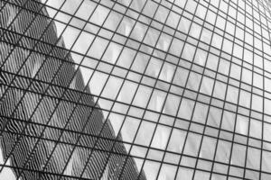 Fragment of a modern office building. Abstract geometric background. Part of a skyscraper with glass windows. Black and white. photo