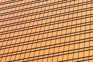 Fragment of a modern office building. Abstract geometric background. Part of a skyscraper with glass windows. photo