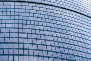 Fragment of a modern office building. Abstract geometric background. Part of a skyscraper with glass windows. photo