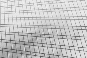 Fragment of a modern office building. Abstract geometric background. Part of a skyscraper with glass windows. Black and white. photo