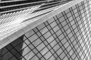 Fragment of a modern office building. Abstract geometric background. Part of a skyscraper with glass windows. Black and white. photo