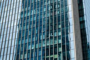 Fragment of a modern office building. Abstract geometric background. Part of a skyscraper with glass windows. photo