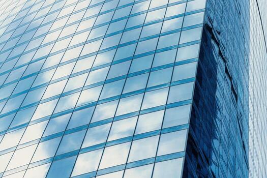 Fragment of a modern office building. Abstract geometric background. Part of a skyscraper with glass windows. photo