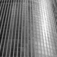 Fragment of a modern office building. Abstract geometric background. Part of a skyscraper with glass windows. Black and white. photo