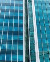 Fragment of a modern office building. Abstract geometric background. Part of a skyscraper with glass windows. photo
