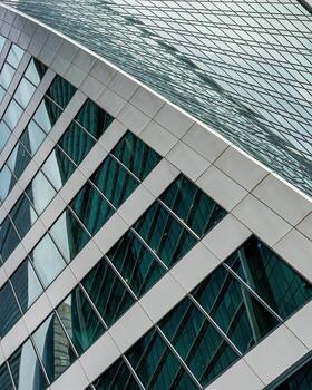 Fragment of a modern office building. Abstract geometric background. Part of a skyscraper with glass windows. photo