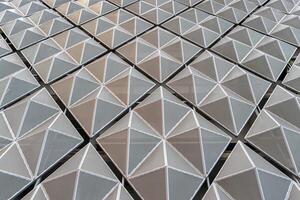 Fragment of a modern building. Abstract geometric background. Part of the facade of a skyscraper with metal diamond-shaped grids. photo