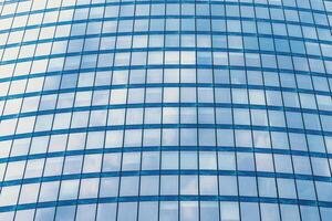 Fragment of a modern office building. Abstract geometric background. Part of a skyscraper with glass windows. photo