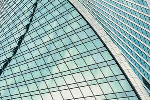 Fragment of a modern office building. Abstract geometric background. Part of a skyscraper with glass windows. photo