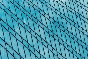 Fragment of a modern office building. Abstract geometric background. Part of a skyscraper with glass windows. photo