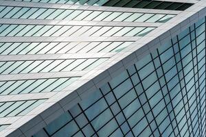 Fragment of a modern office building. Abstract geometric background. Part of a skyscraper with glass windows. photo