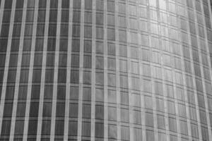 Fragment of a modern office building. Abstract geometric background. Part of a skyscraper with glass windows. Black and white. photo