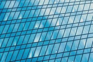 Fragment of a modern office building. Abstract geometric background. Part of a skyscraper with glass windows. photo