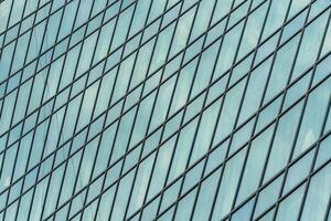Fragment of a modern office building. Abstract geometric background. Part of a skyscraper with glass windows. photo