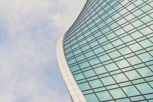 Fragment of a modern office building. Abstract geometric background. Part of a skyscraper with glass windows. photo