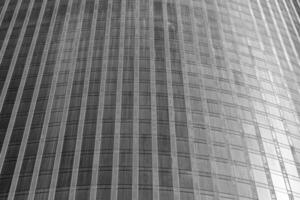 Fragment of a modern office building. Abstract geometric background. Part of a skyscraper with glass windows. Black and white. photo
