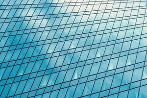 Fragment of a modern office building. Abstract geometric background. Part of a skyscraper with glass windows. photo